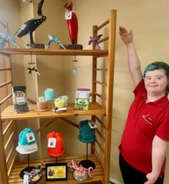 woman standing next to showcase of handmade products